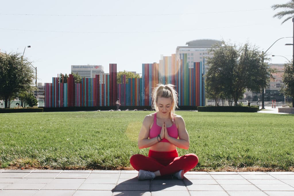 jillian travel and wellness influencer sitting in a seated yoga pose doing a meditation