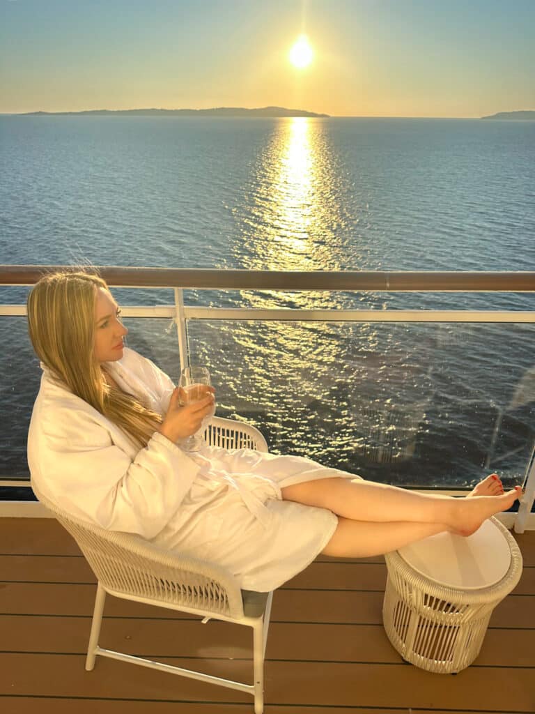 jillian, travel and wellness influencer on a private patio on a cruise ship and why i love cruises