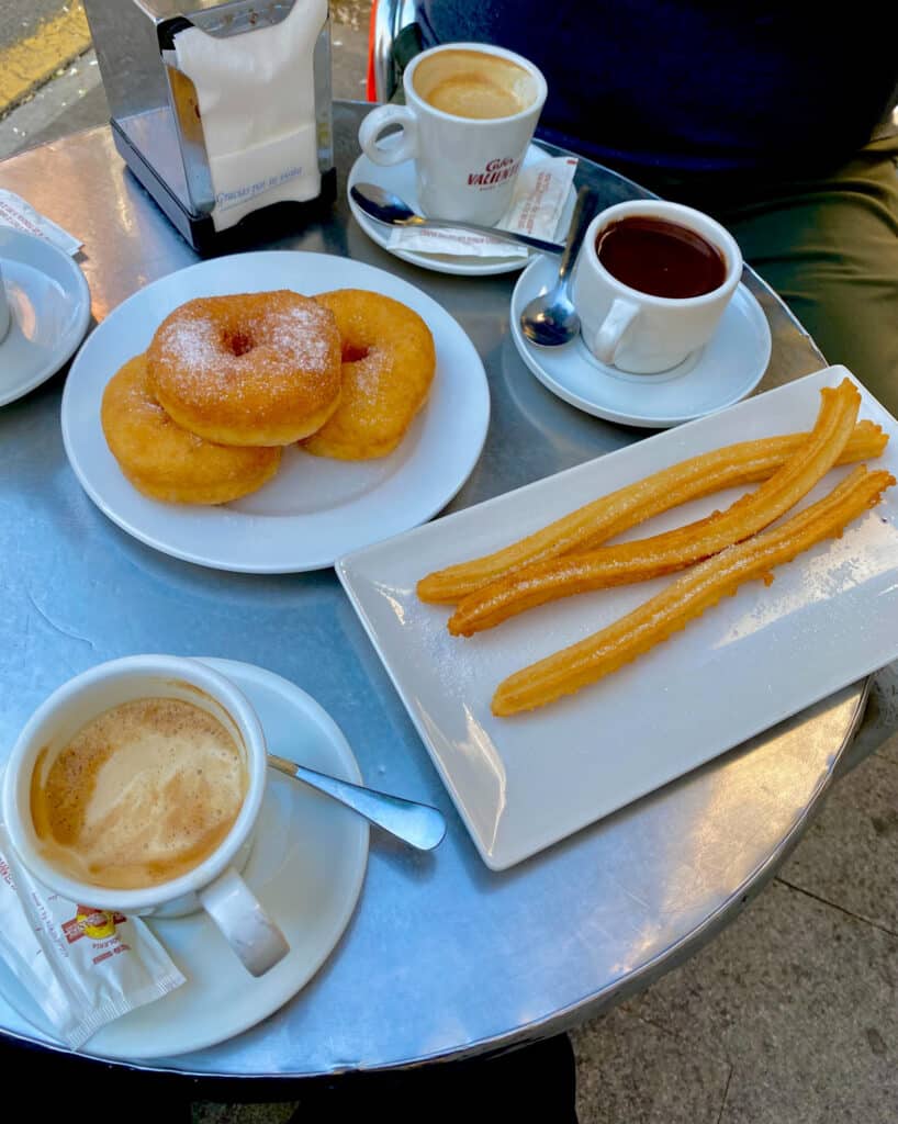 breakfast in spain with coffee, hot chocolate, churros, and donuts