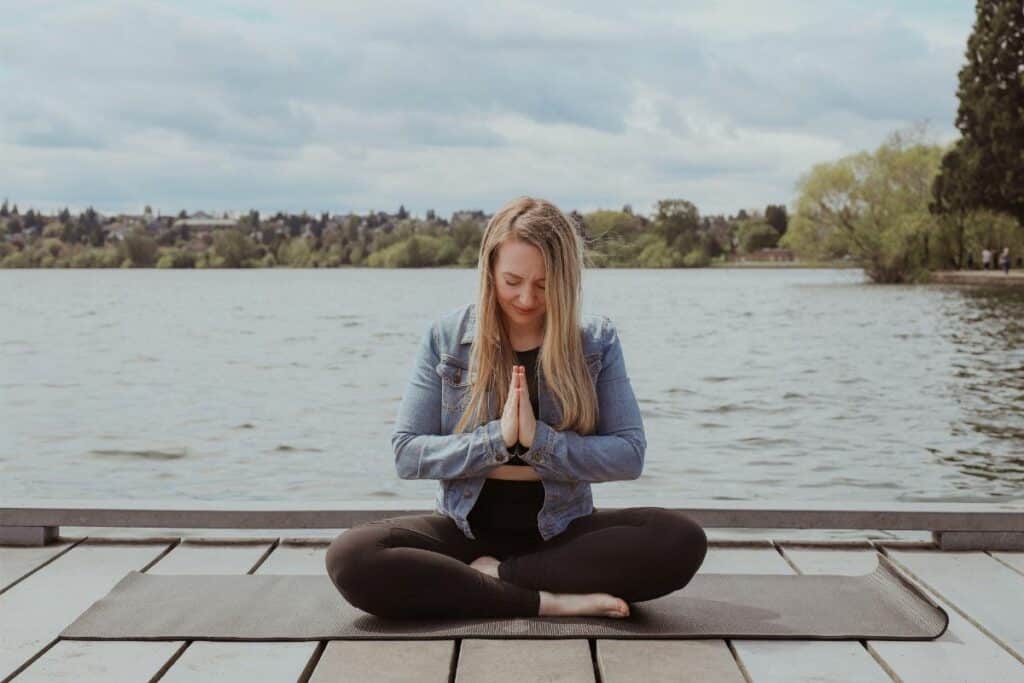 jillian, travel and wellness influencer, practicing her mind-body connection by the lake